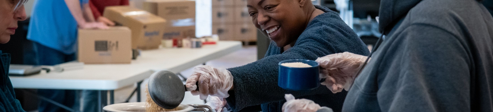 A woman preparing a meal kit for Feed My Starving Children