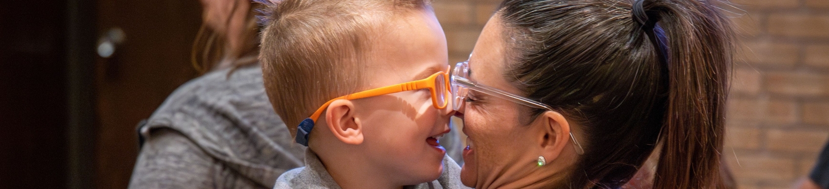 A young boy and his mother hug each other.