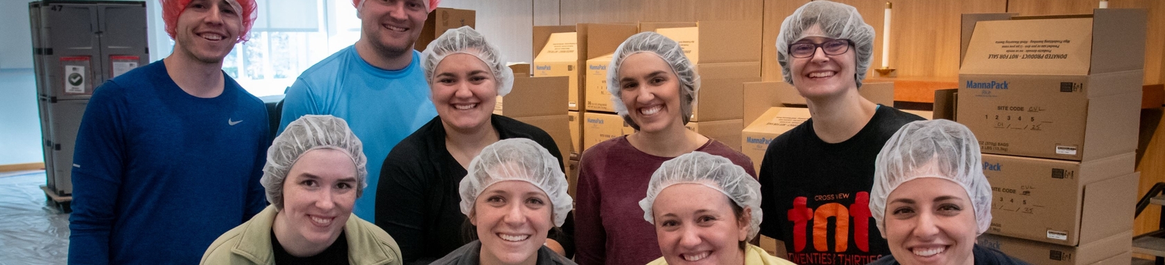 Nine people in their 20s and 30s smile at a servant event