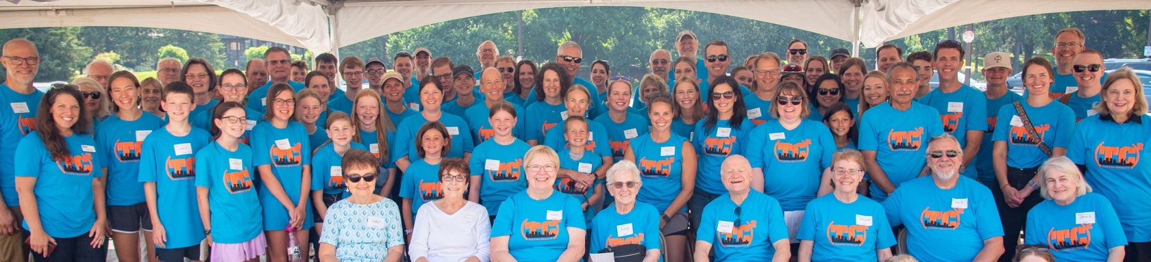 Fifty people in matching t-shirts in a posted photo at a service event.