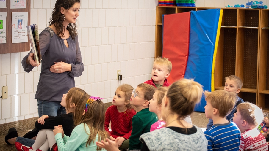 A woman reads a story to group of young children during Sunday school.