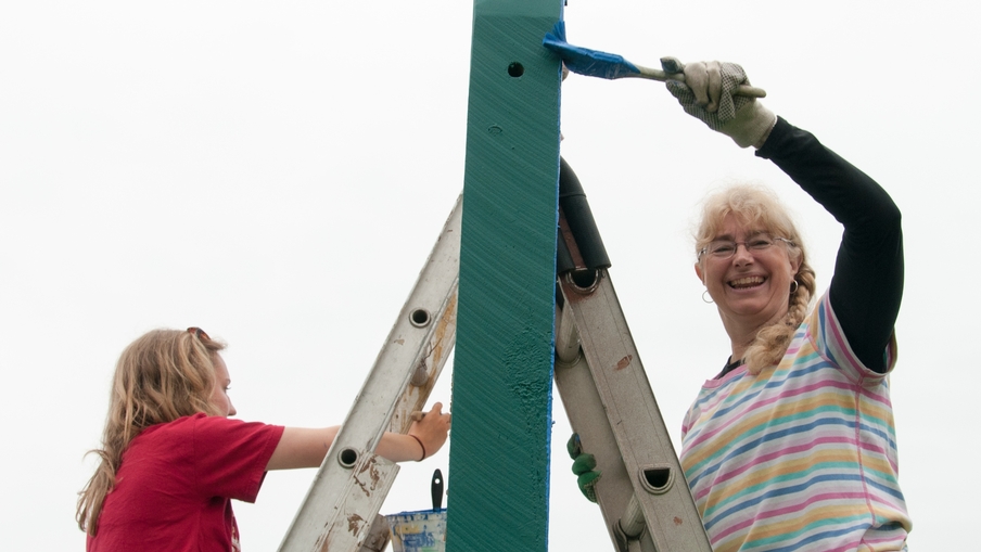 Two women painting on a mission trip to Grand Marais