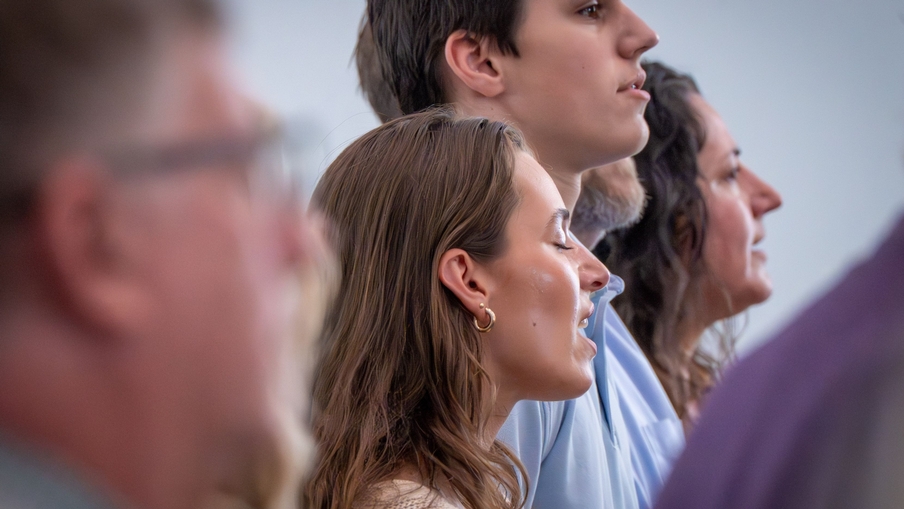 A female high school student sings with a high school boy and their mother. A female high school student sings with a high school boy and their mother.