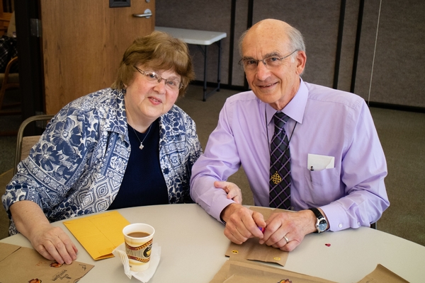 A senior citizen couple sitting at a table smiling