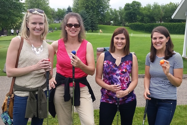 Four young adult women mini golfing