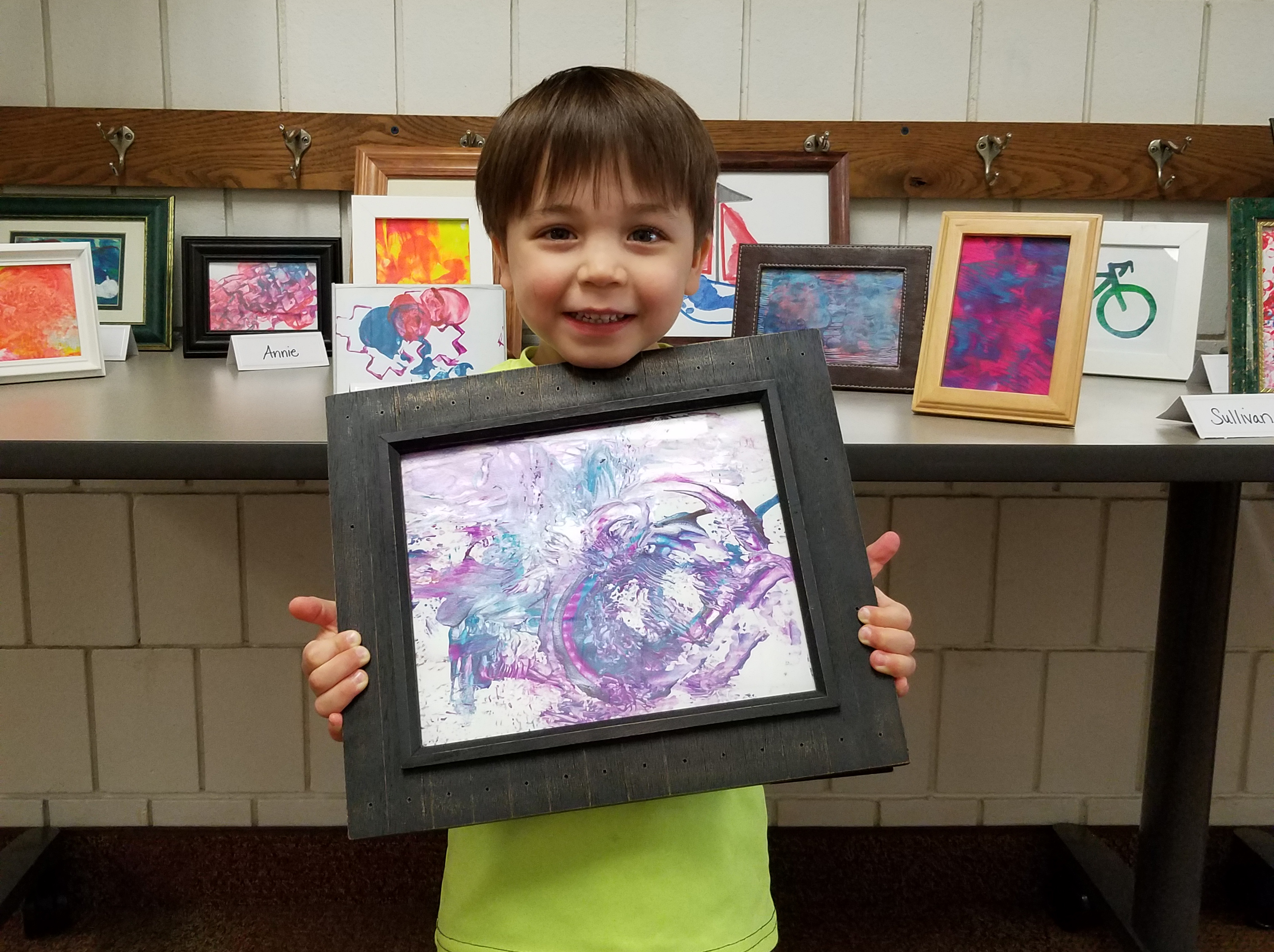 An ECC boy holds his framed painting