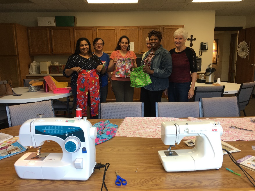 Immigrant women and POBLO volunteers show their sewing projects.